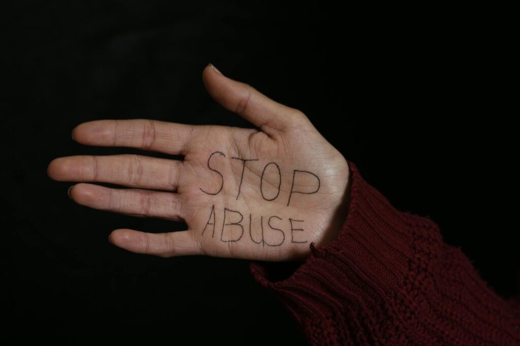 woman showing her palm with stop abuse text written on it