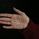 woman showing her palm with stop abuse text written on it